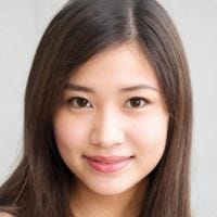 Young woman with long straight dark hair and a gentle smile, facing the camera against a neutral light background.