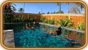 Penida Three people in a backyard pool practicing scuba gear with "Legend Diving" logo visible on an instructor's wetsuit.